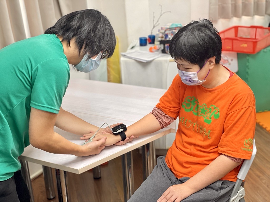 天鵝堡運用穿戴式裝置監測憨兒心率、血氧，強化健康管理機制。