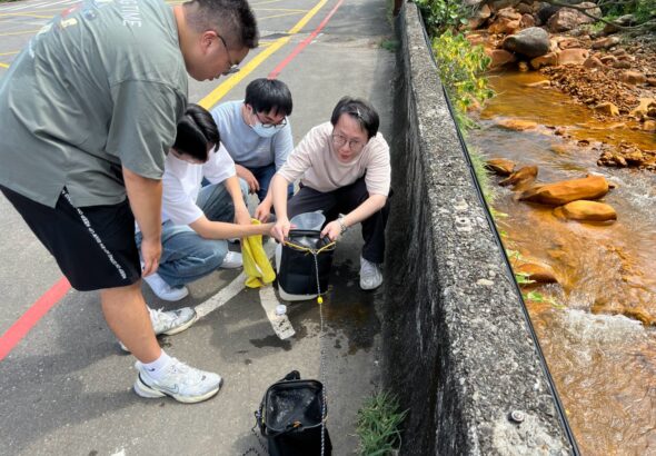 圖4、研究團隊於陰陽海出海口採集表層海水。水道中的黃褐色沉積物為酸性礦排水與海水