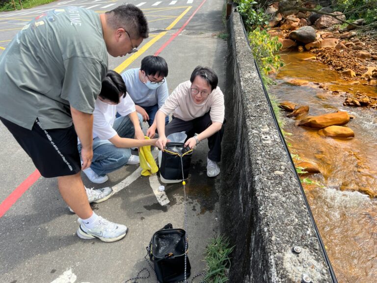 圖4、研究團隊於陰陽海出海口採集表層海水。水道中的黃褐色沉積物為酸性礦排水與海水